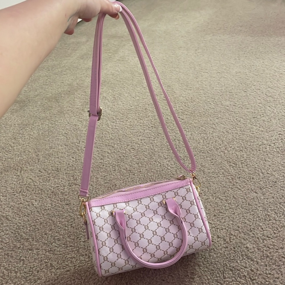 pink shoulder purse with gold design and adjustable length